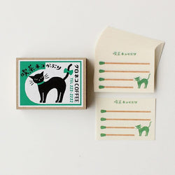 Matchbox set with black cat illustration and green text on a white background
